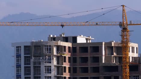 Tower-Crane-on-a-Construction-Site-Lifts-a-Load-at-High-rise-Building