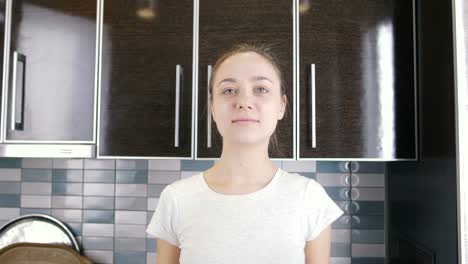 young-woman-showing-smart-phone-screen-on-the-kitchen