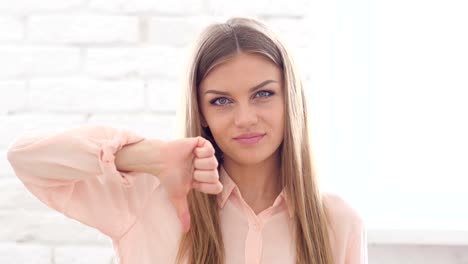 Daumen-runter-von-jungen-Frau,-Blick-in-die-Kamera-im-Büro