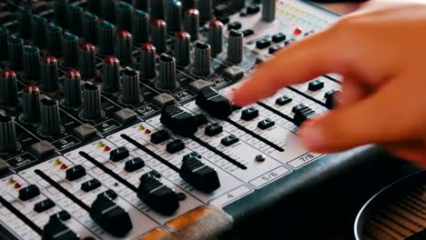 DJ-console-or-mixer,-the-hand-presses-the-levers-and-buttons-of-remote