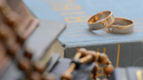 Dos-anillos-de-boda-con-cros-en-el-bookshelh,-zoom,-disparo-con-slider