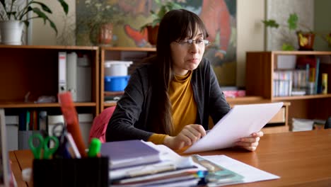 The-young-teacher-in-glasses-in-the-classroom-checking-independent-tests.