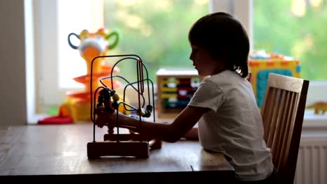 Niño-preescolar,-jugando-con-los-juguetes-en-una-habitación-soleada,-desarrollo-infantil