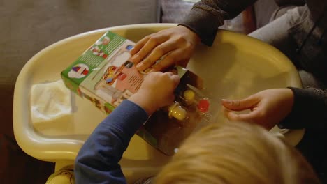 Video-Of-A-Young-Toddler-Boy-Making-A-Christmas-Wooden-Toy-Soldier-Craft-With-His-Mom-At-Their-Living-Room-Table