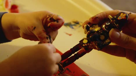 Video-Of-A-Young-Toddler-Boy-Making-A-Christmas-Wooden-Toy-Soldier-Craft-With-His-Mom-At-Their-Living-Room-Table