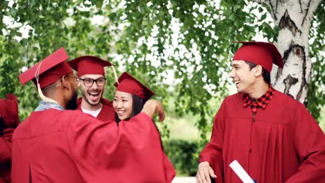 Entusiasmados-jóvenes-hombres-y-mujeres-graduados-están-haciendo-chocan,-abrazándose-y-riendo-diplomas-celebración-celebrando-el-día-de-la-graduación.-Las-emociones-y-el-concepto-de-éxito.