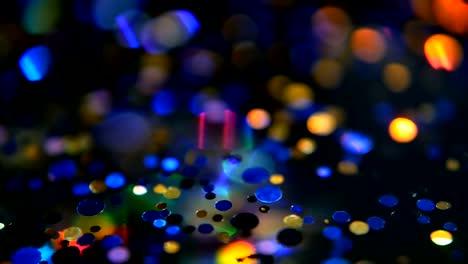 Defokussierten-schillernden-bunten-Glitter-Konfetti,-schwarzer-Hintergrund.-Urlaub-abstrakte-festliche-Bokeh-Lichtpunkte.