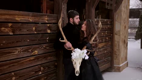 Pareja-en-ropa-de-color-negro-con-una-calavera-bajo-la-nieve