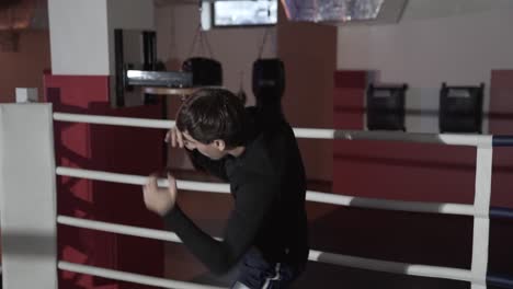 Close-up-of-a-cropped-frame-of-a-young-man-in-sports-shorts-and-Rashgarde-works-out-the-technique-of-boxing-punches,-moves-in-the-ring,-trains-on-his-own,-prepares-for-battle