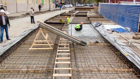 Obras-de-hormigón-para-construcción-de-mantenimiento-de-carreteras-con-muchos-trabajadores-y-mezclador-timelapse