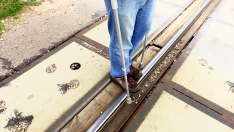 Disabled-man-with-crutches-trying-to-walk-over-railway-crossings