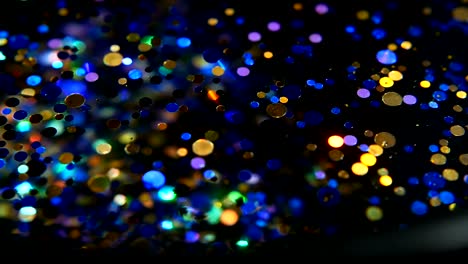 Defocused-shimmering-multicolored-glitter-confetti,-black-background.-Party,-magic,-imagination.-Rainbow-colors,-sparkle-circles.-Holiday-abstract-festive-texture-of-shiny-blurred-bokeh-light-spots.