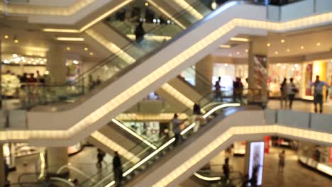 People-Using-Escalator-In-Shopping-Mall-Centre