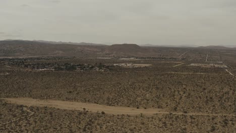 Flying-over-trees-and-houses-in-the-desert.