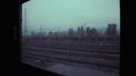 Starker-Regen-dramatische-Überfüllung-hinter-dem-alten-historischen-Zugfenster-am-Bahnhof-in-super-langsam-Motin.