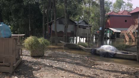 Aguas-de-la-inundación-en-palafitos-con-pequeñas-canoas-en-patio.