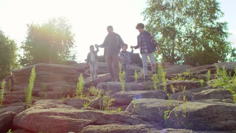 Aktive-Familie-mit-Kindern-zu-Fuß-durch-Felsen