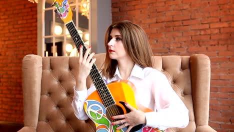 Girl-in-white-shirt-posing-with-a-guitar-in-hippie-style