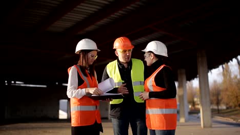 Die-Vorarbeiter-und-zwei-Frauen-Inspektoren,-die-Besichtigung-der-Baustelle.