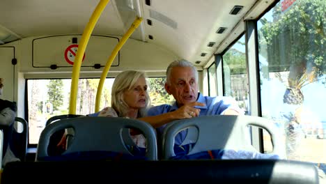 Senior-pareja-interactuando-con-los-demás-mientras-viaja-en-autobús-4k