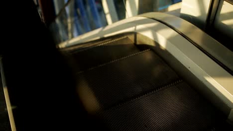 Close-up-of-the-steps-of-a-downward-escalator-in-a-mall-or-at-the-airport-without-people