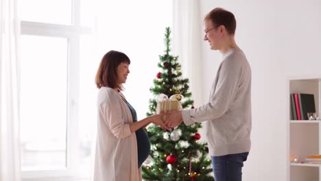 husband-giving-christmas-present-to-pregnant-wife