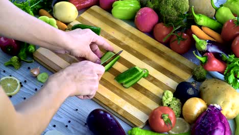 Man-is-cutting-vegetables-in-the-kitchen,-slicing-cucumber-in-slow-motion