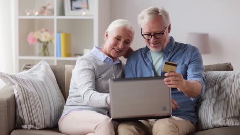 feliz-pareja-senior-con-laptop-y-tarjeta-de-crédito