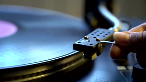 Cinemagraph-viejo-vinilo-tocadiscos-y-mujer-mano-holding-stylus-con-la-placa-de-aguja-y-spinning