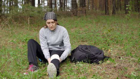 young-woman-renders-herself-first-aid-after-injuring-herself-in-the-forest