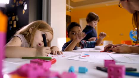 Niños-multiculturales-disfrutando-de-dibujo-en-clase-de-arte