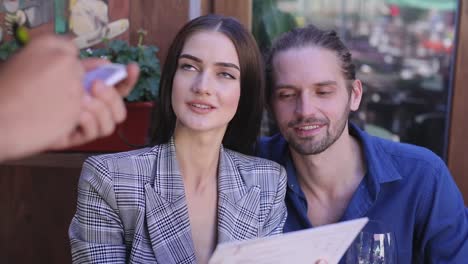 Couple-At-Restaurant.-People-With-Menu-Making-Order-At-Cafe