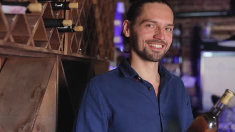 Handsome-Man-Holding-Bottle-Of-Wine-At-Wine-Cellar