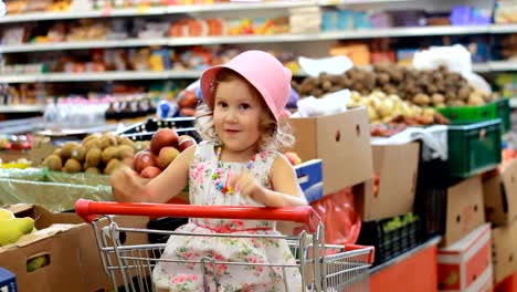 Ladenrabatte.-Ausverkauf.-Kindermädchen-in-einem-Supermarkt-sitzt-in-einem-Einkaufswagen