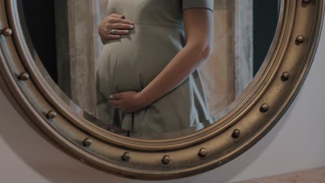 Pregnant-woman-touching-belly,-mirror-reflection