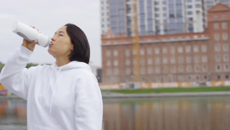 Asian-Mother-and-Son-Drinking-Water-after-Run-Workout-Outdoors