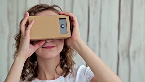 Young-curly-woman-using-Virtual-Reality-Glasses