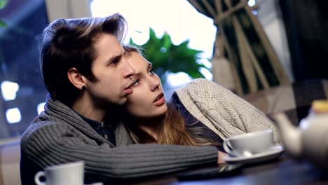 Loving-young-couple-hugging-while-resting-in-cafe