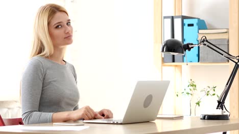 Thumbs-Down,--Woman-Gesturing-while-Sitting-in-Office