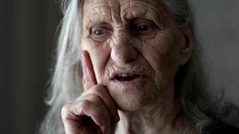 Portrait-of-old-woman-with-grey-hair-telling-story.