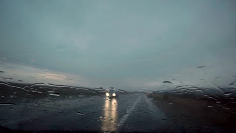 Rain-drops-on-the-window.-Abstract-background-of-cars-headlights-moving-along-road