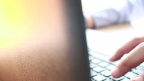 businessman-typing-on-a-laptop-keyboard-in-blurred-focus