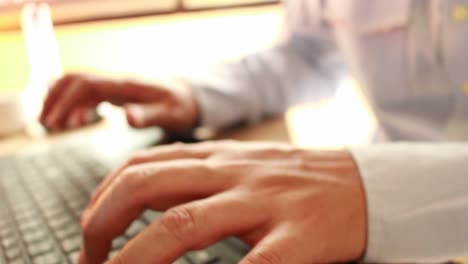 businessman-typing-on-a-laptop-keyboard-in-blurred-focus