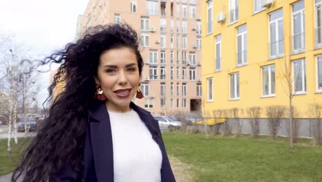 Beautiful-brunette-journalist-talks-with-camera-and-walks-on-the-street