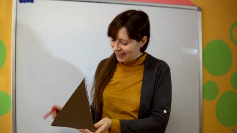 Weibliche-Lehrer-Stand-in-der-Nähe-von-Tafel-im-Unterricht-der-Grundschule.