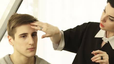 Woman-hairstylist-making-male-hairstyle-in-hairdressing-salon.-Close-up-barber-doing-male-hairdo-during-working-with-client-in-beauty-studio