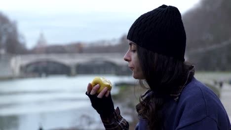 junge-Obdachlose-Frau-isst-einen-Apfel-und-jemand-grüßt