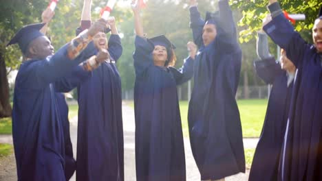 glückliche-Schüler-in-Mörtel-Boards-mit-Diplomen