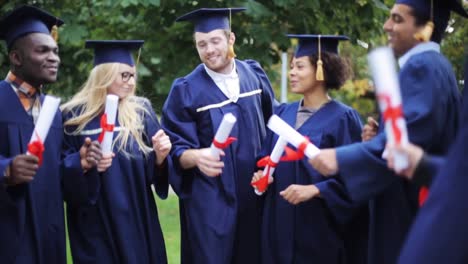 glückliche-Schüler-in-Mörtel-Boards-mit-Diplomen