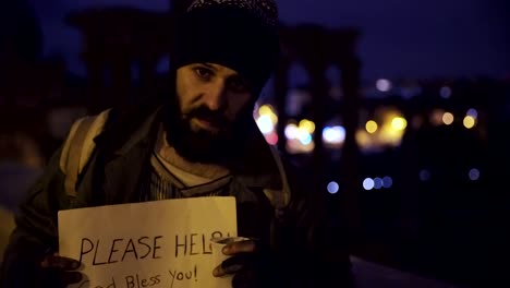 despair,-misery,-marginalization--Sad,lonely-beggar-in-the-street-at-night